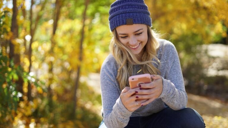 woman wearing knit hat holding phone