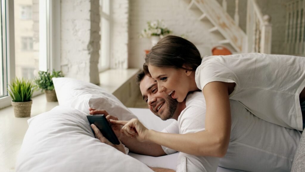 Couple in bed looking at tablet together at tablet