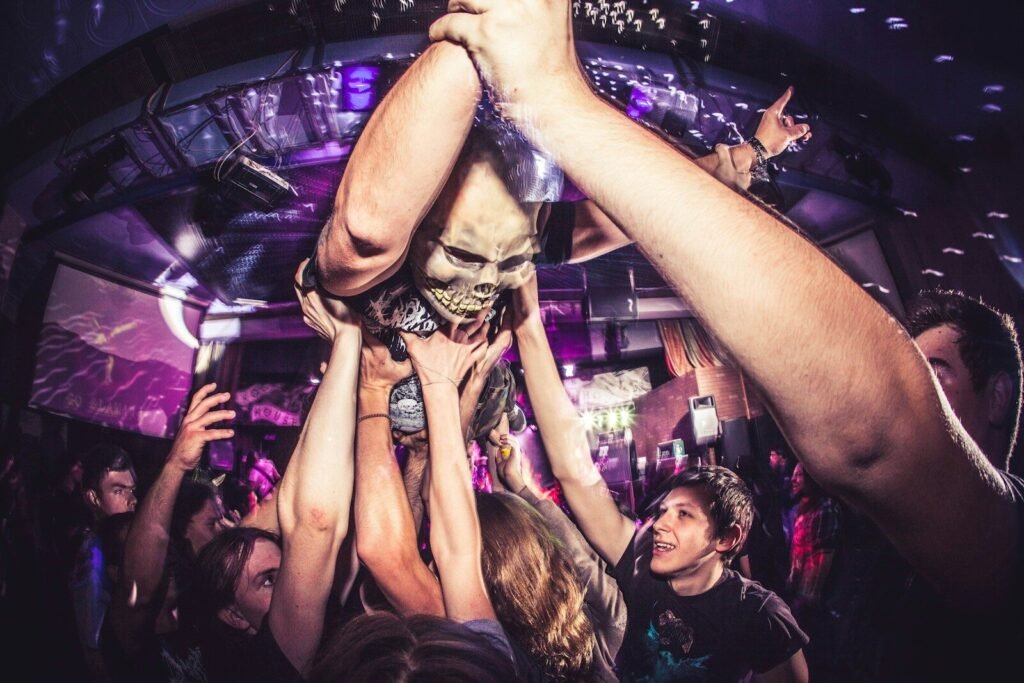 a group of people standing around each other with their hands in the air