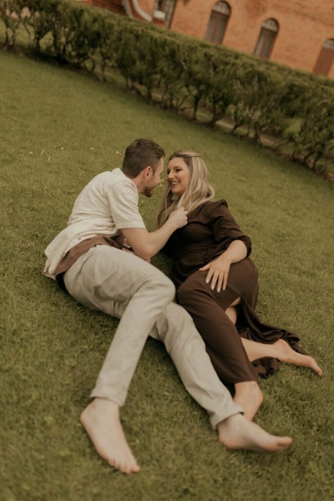 A couple relaxing together on a grassy lawn.