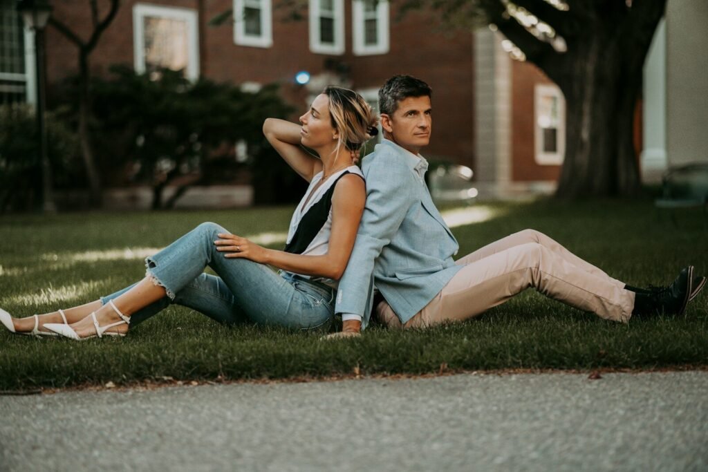 a man and woman sitting on grass