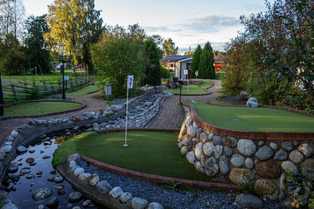A golf course with a small pond in the middle of it