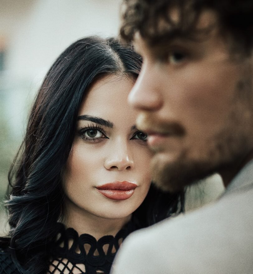 A woman in a black dress standing next to a man
