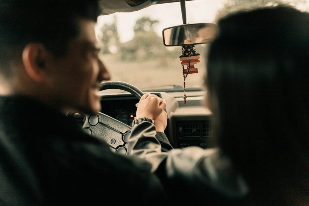 A man driving a car next to a woman