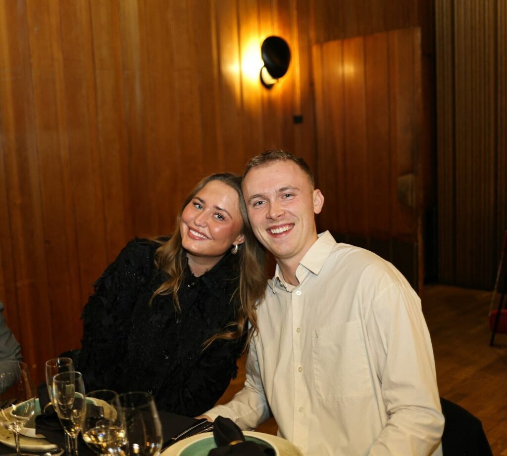 A couple smiling at a dinner table