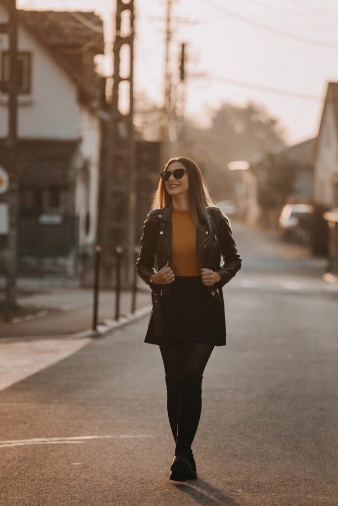 Woman walking down a street at sunset
