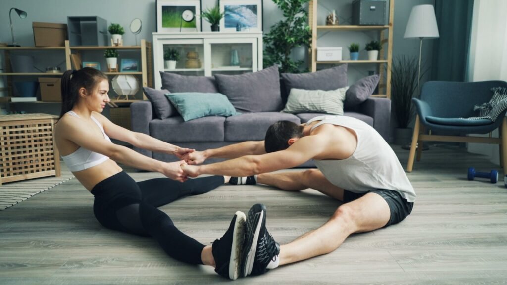 a man and a woman are doing exercises in a living room