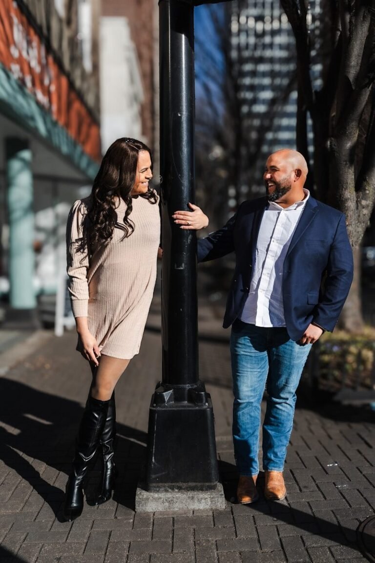 A man and a woman standing next to a street sign