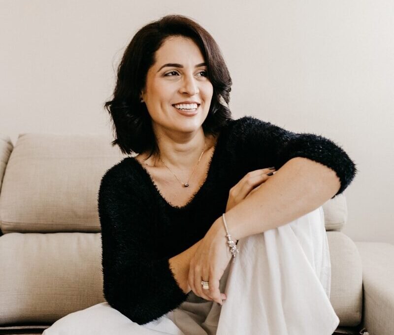 woman in black long sleeve shirt sitting on white couch