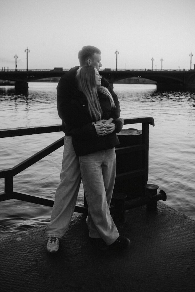 Couple embracing on a waterfront at dusk