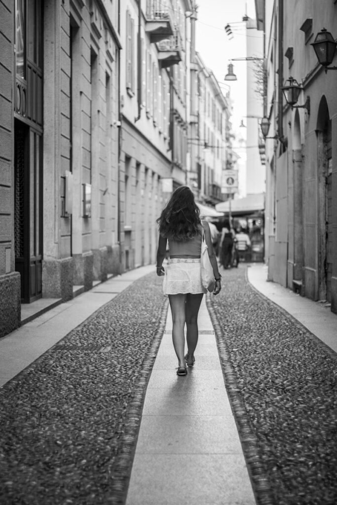 Woman walking down a cobblestone street in italy.