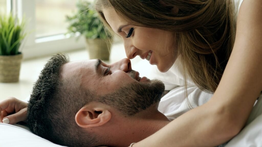 Couple lying in bed, noses touching