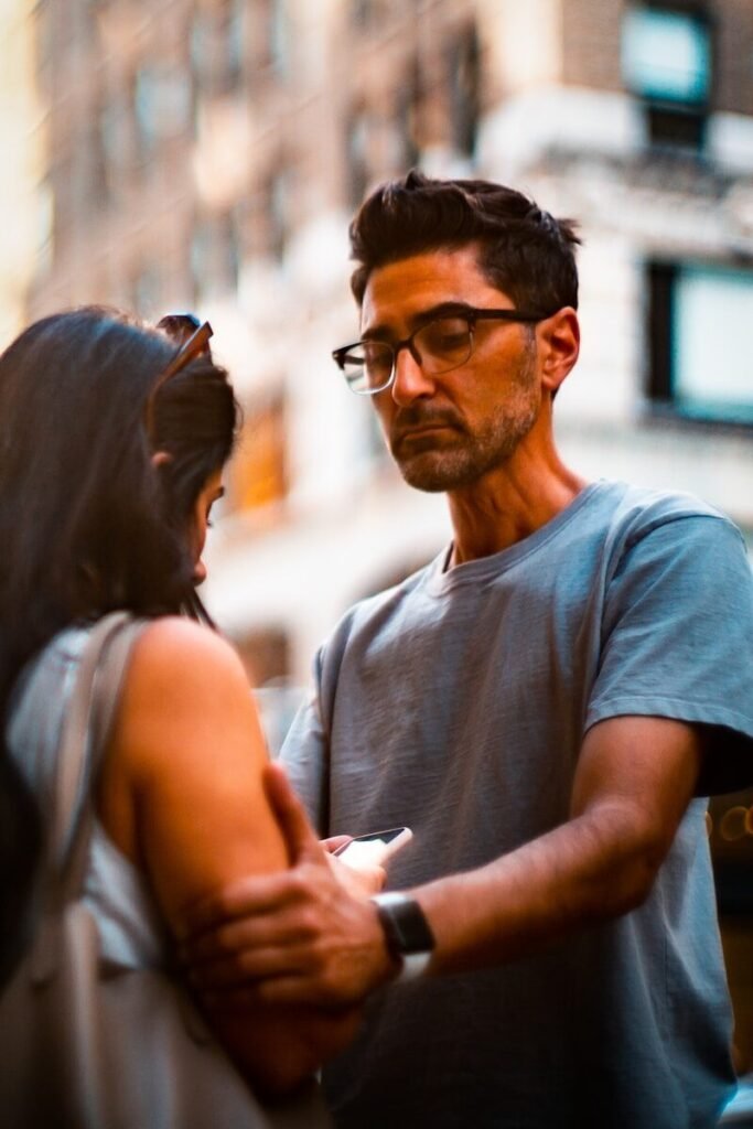 man holding woman's shoulder