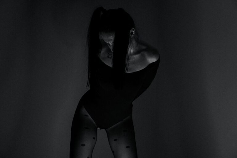 a woman in a black bodysuit with polka dots on her tights