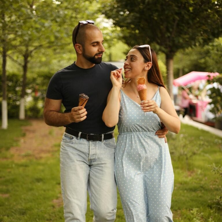 A happy couple walking and enjoying ice cream cones in a lush Armenian park.