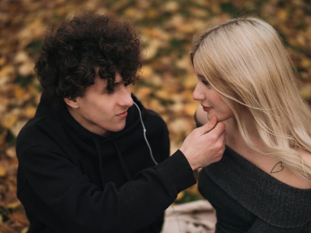 A young couple sharing an intimate moment outdoors during fall.