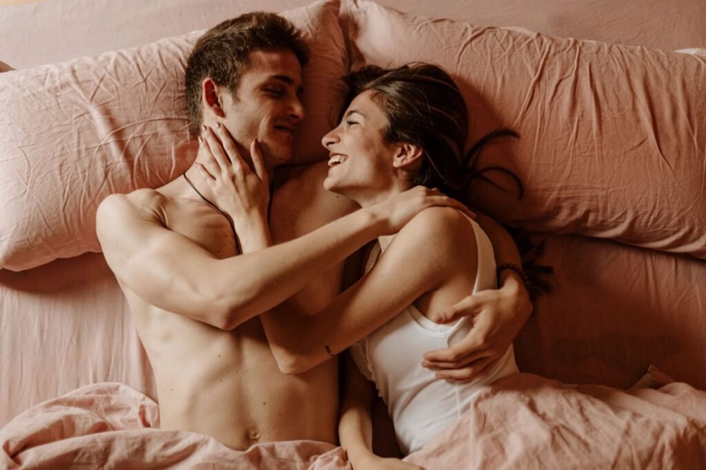 A loving couple lying together in an intimate embrace, sharing a joyful moment.