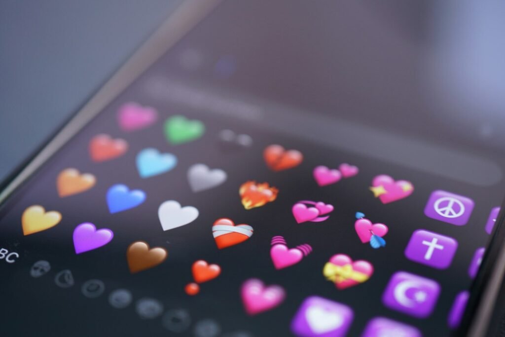 A phone screen displays colorful heart emojis.
