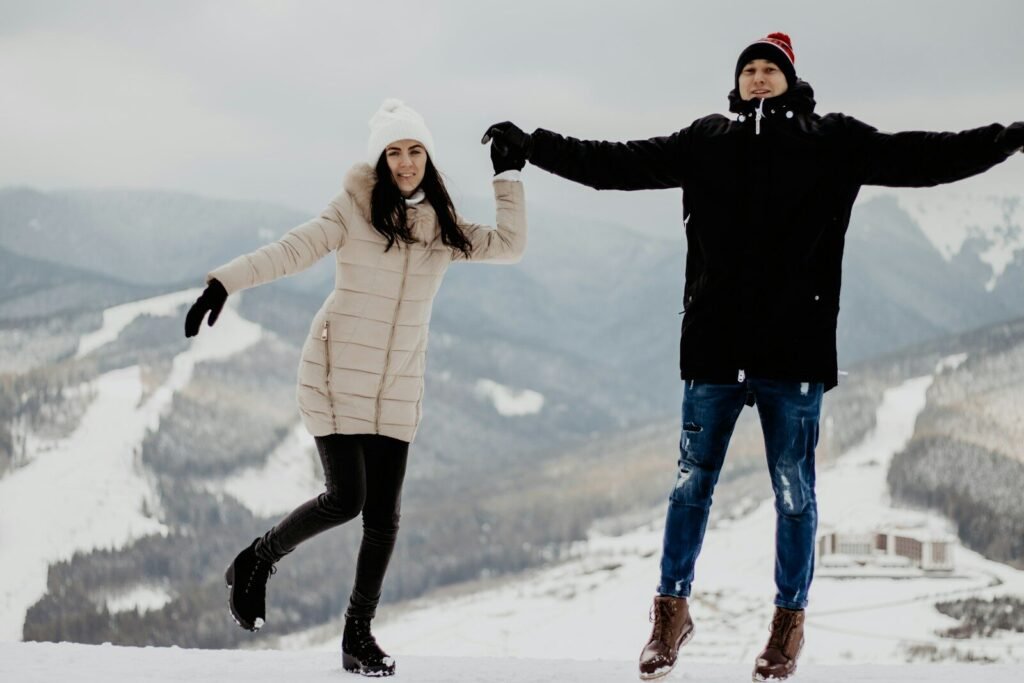 2 women standing on snow covered ground during daytime