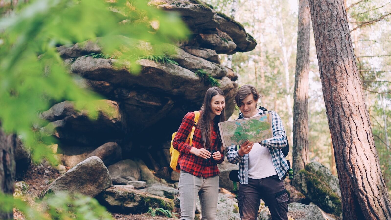 Couple looking at map in a forest