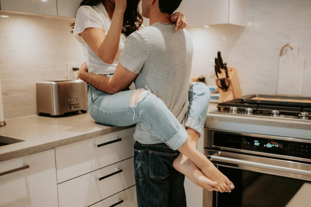 a man holding a woman in his arms in a kitchen